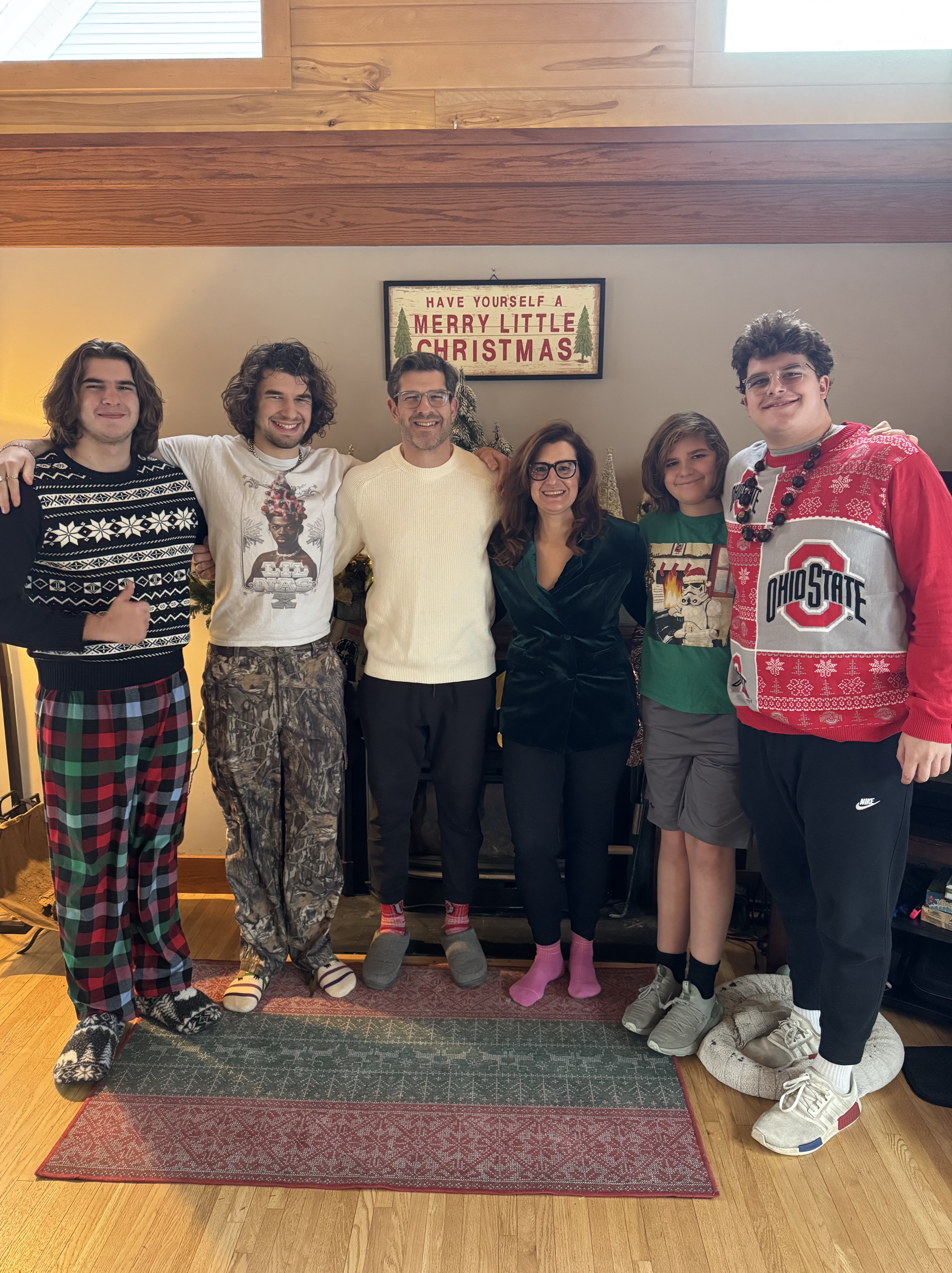 Claire and her husband and four children in front of a fireplace